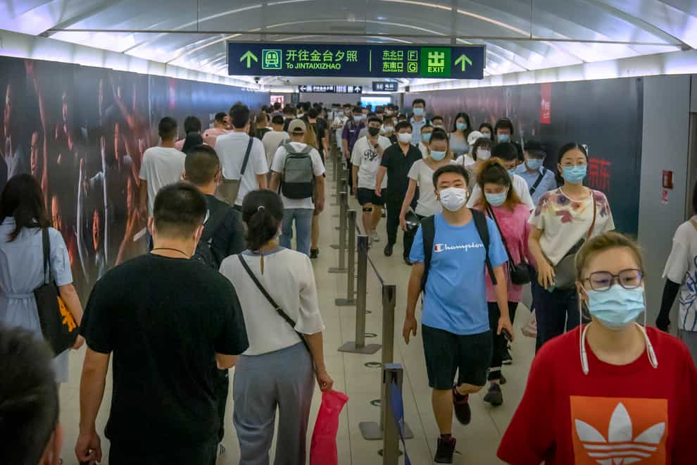 People wearing face masks to help protect against COVID-19 walk through a subway station during the morning rush hour in Beijing, Wednesday, Aug. 4, 2021. China’s worst coronavirus outbreak since the start of the pandemic a year and a half ago escalated Wednesday with dozens more cases around the country, the sealing-off of one city and the punishment of its local leaders. (AP Photo/Mark Schiefelbein)