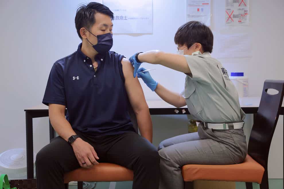 A visitor receives a shot of the Pfizer vaccine at the Tokyo Vaccination Centre (Stanislav Kogiku/AP)