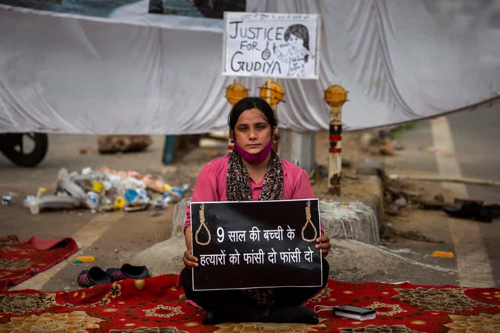 Tina Verma, 27, a social activist, holds a placard which reads: ‘Hang the killers of 9-year old child’ (AP)