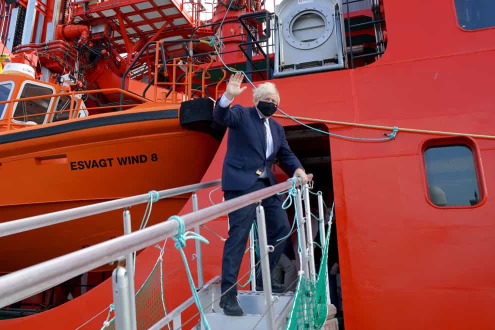 Prime Minister Boris Johnson waves as he boards the vessel Alba in Fraserburgh Harbour, Aberdeenshire (Jane Barlow/PA)
