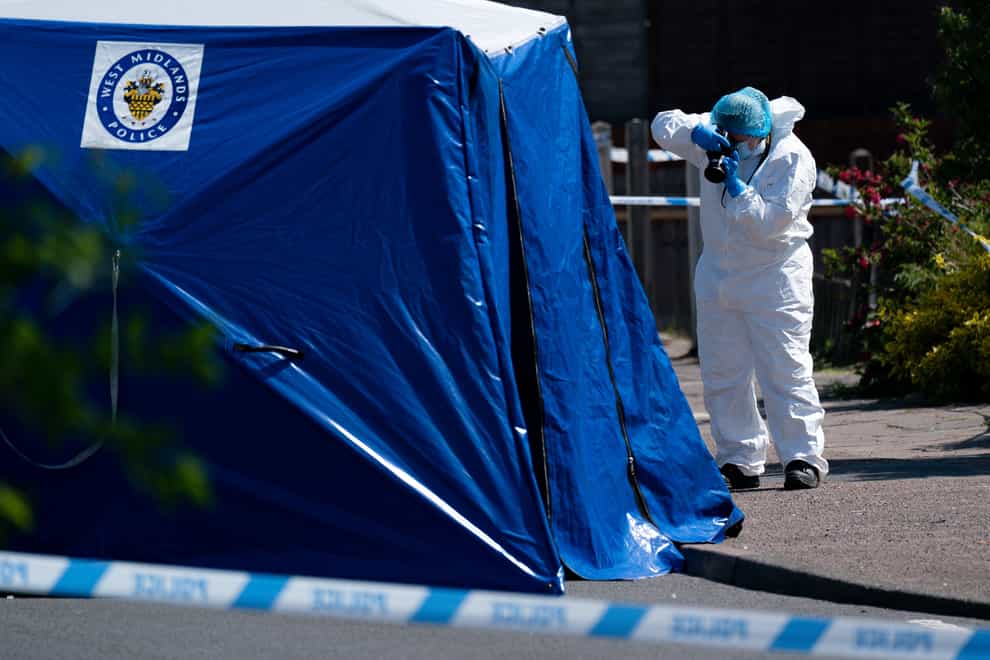 A forensics officer takes photographs at the scene of the stabbing on College Road, Kingstanding (Jacob King/PA)
