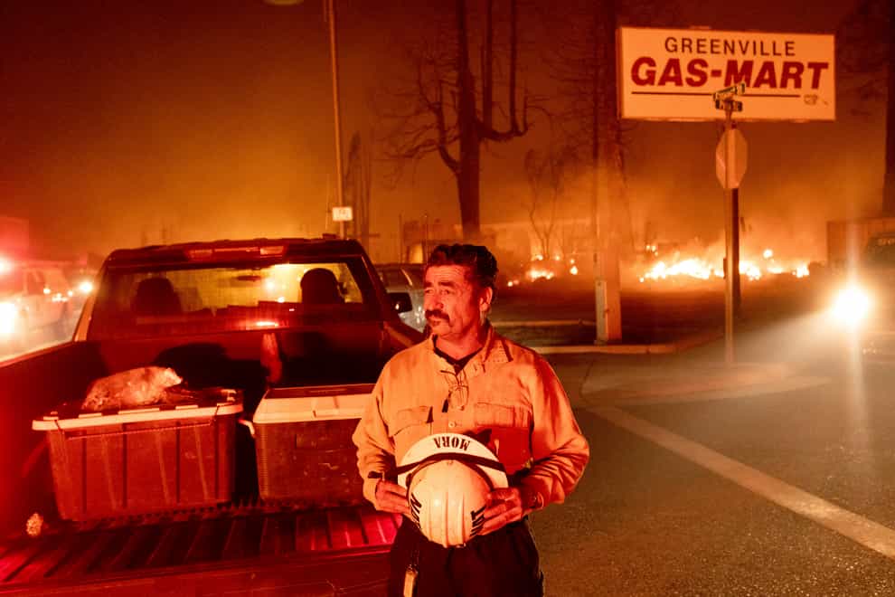 Battalion Chief Sergio Mora watches as the Dixie Fire tears through the Greenville community of Plumas County (Noah Berger/AP)
