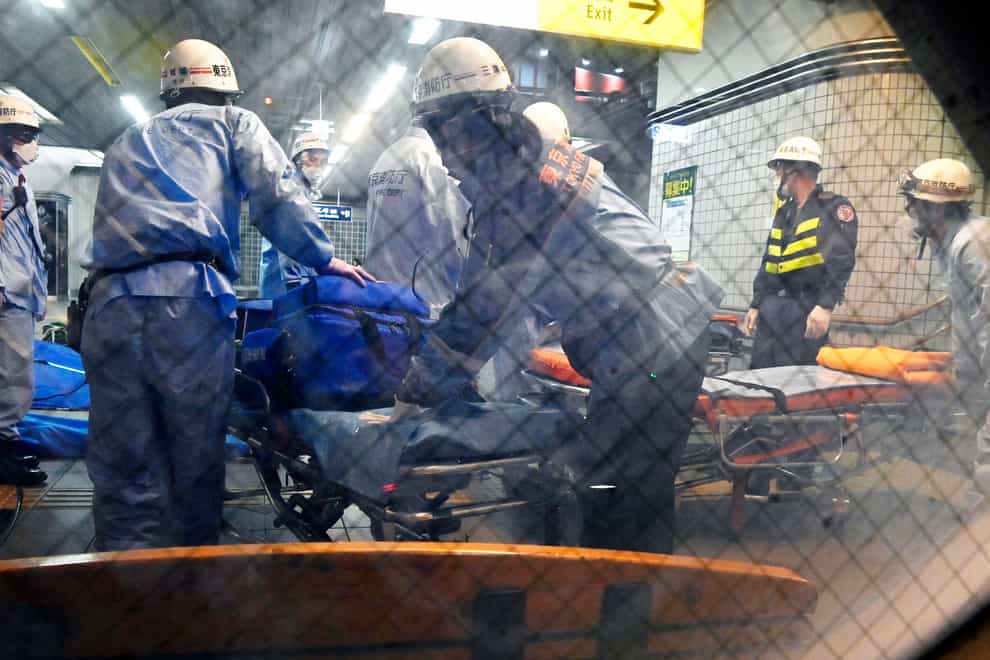 Rescuers prepare stretchers at Soshigaya Okura Station (Kyodo News via AP)