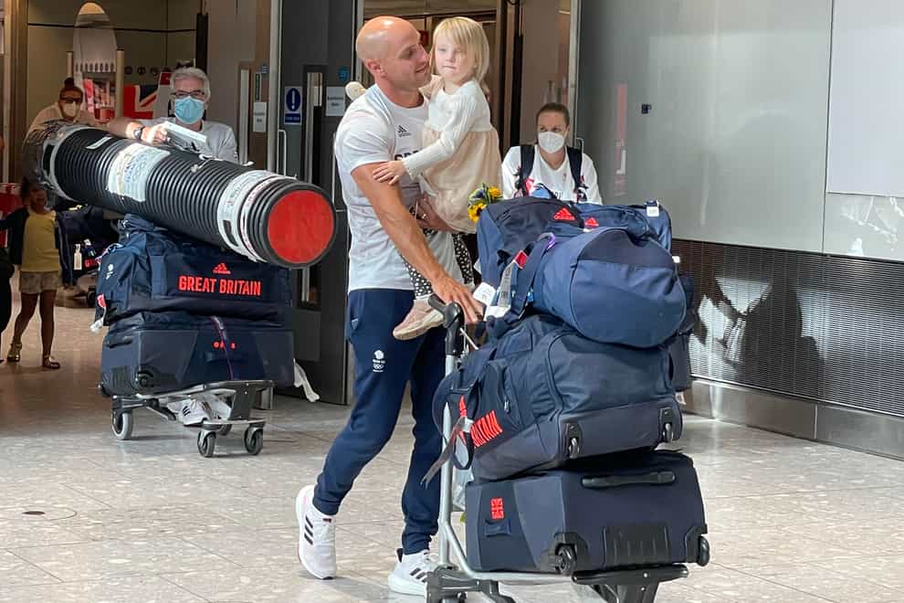 Canoeist Liam Heath is reunited with his three-year-old daughter Sarah at Heathrow Airport (Elmira Tanatarova/PA)