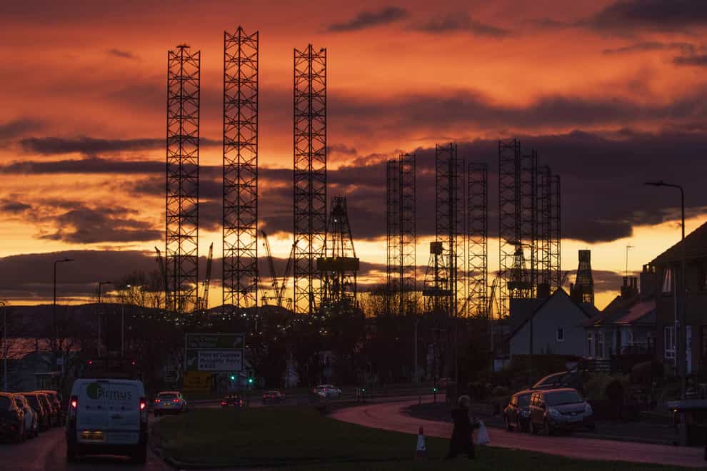 Jack-up rigs used in the North Sea oil and gas industry silhouetted against the sunset (Jane Barlow/PA)