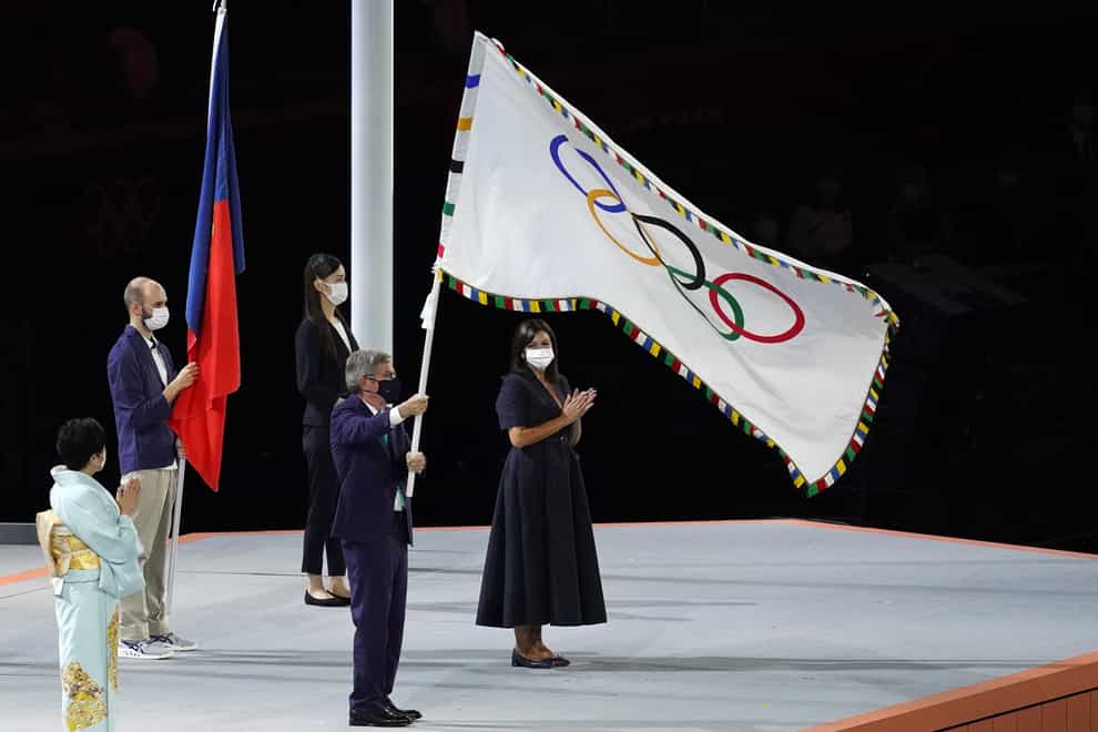 The Olympic flag is handed over by IOC president Thomas Bach to Paris mayor Anne Hidalgo during the closing ceremony of Tokyo 2020 (Martin Rickett/PA Images).