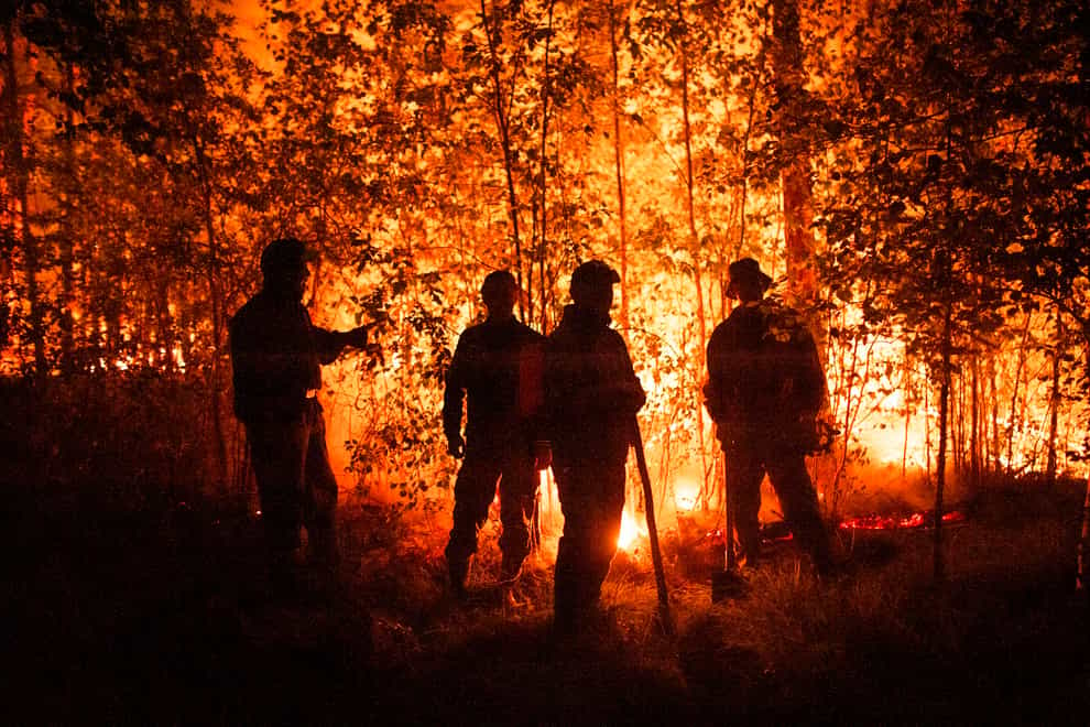 Firefighters work at the scene of forest fire near Kyuyorelyakh village at Gorny Ulus area, west of Yakutsk, in Russia (Ivan Nikiforov/AP)