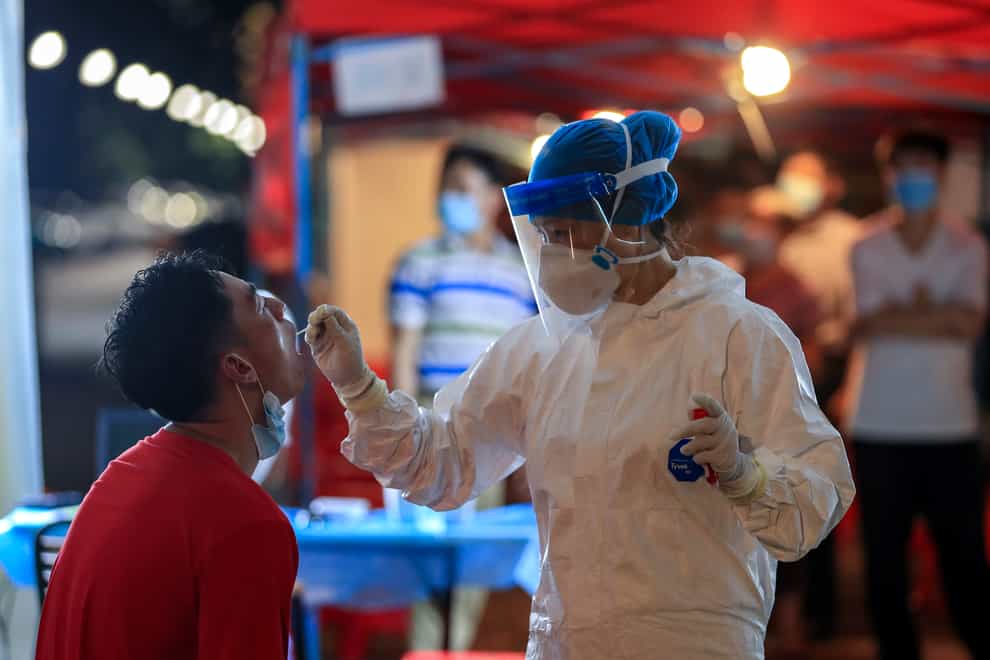 A medical worker takes swab sample from a resident during a round of mass COVID-19 test in Wuhan in central China’s Hubei province (Chinatopix/AP)