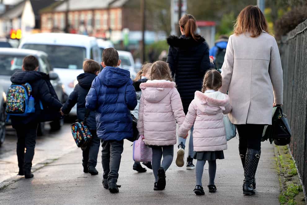 Parents walk their children to school in Hornchurch, Essex (PA)