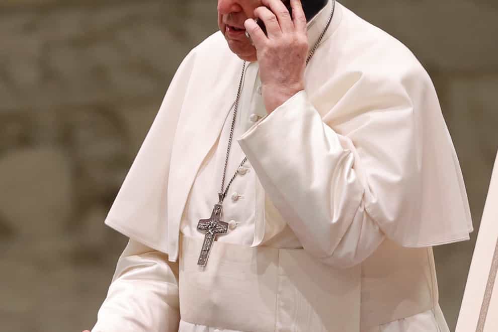 Pope Francis accepts a phone call during his audience with the public at the Vatican (AP Photo/Riccardo De Luca)