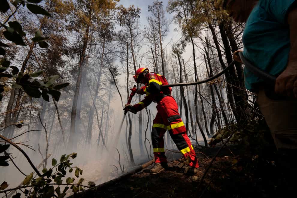 A firefighter from Slovakia tries to extinguish a fire on the island of Evia (Petros Karadjias/AP)