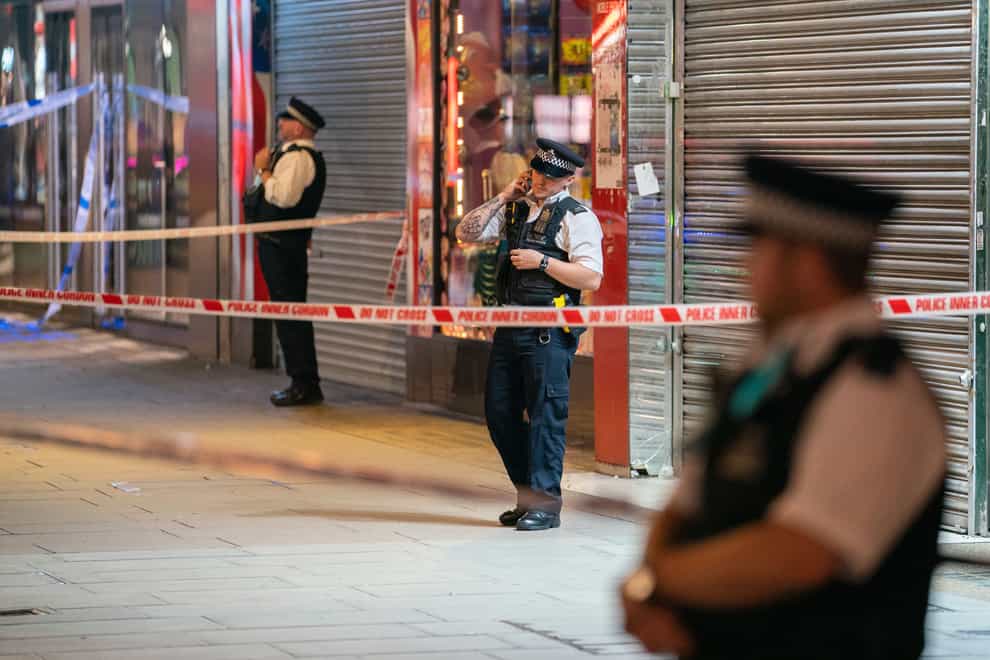 Metropolitan Police officers at the scene on Oxford Street, London, where a man was found just after 7pm with multiple stab wounds (Dominic Lipinski/PA)