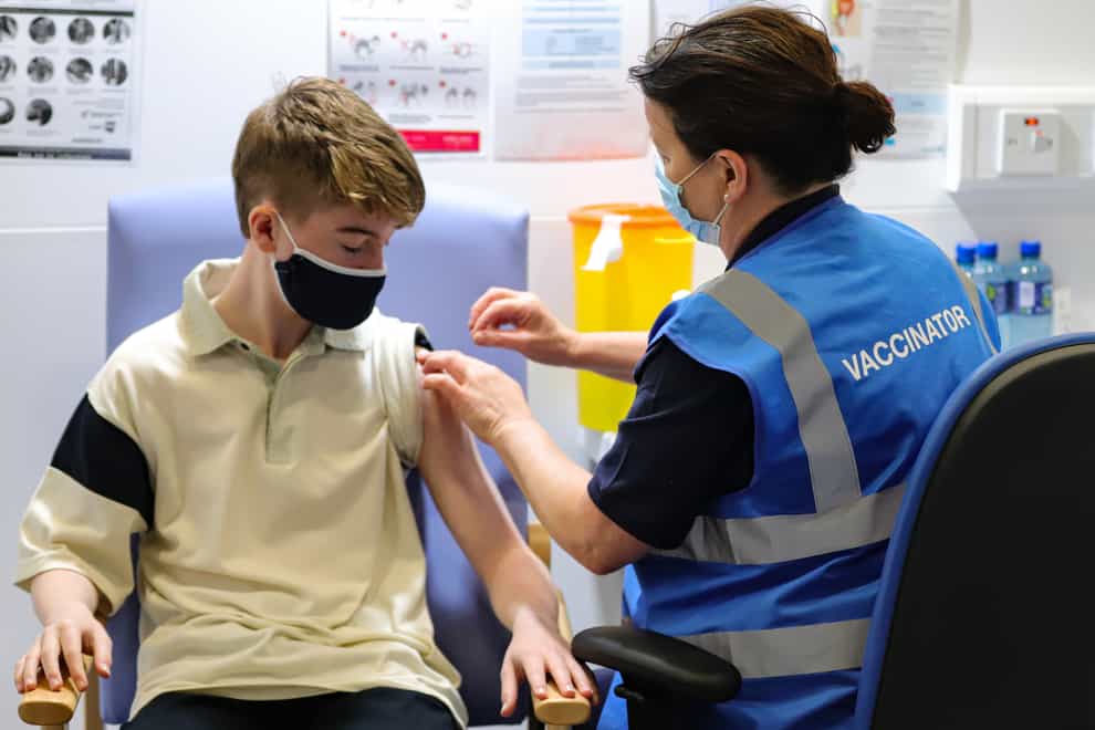 Kevin Mckeon, 14, receives his first dose of the Covid-19 vaccine from vaccinator Geraldine Flynn at the Citywest vaccination centre in Dublin (PA)