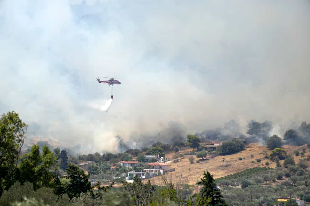 A helicopter drops water over Markati village about 37 miles south of Athens (Thnassis Stavrakis/AP)