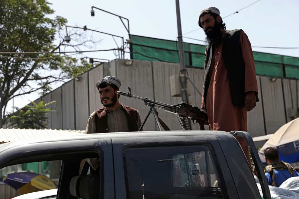 Taliban fighters stand guard on the back of vehicle in Kabul (Rahmat Gul/AP/PA)