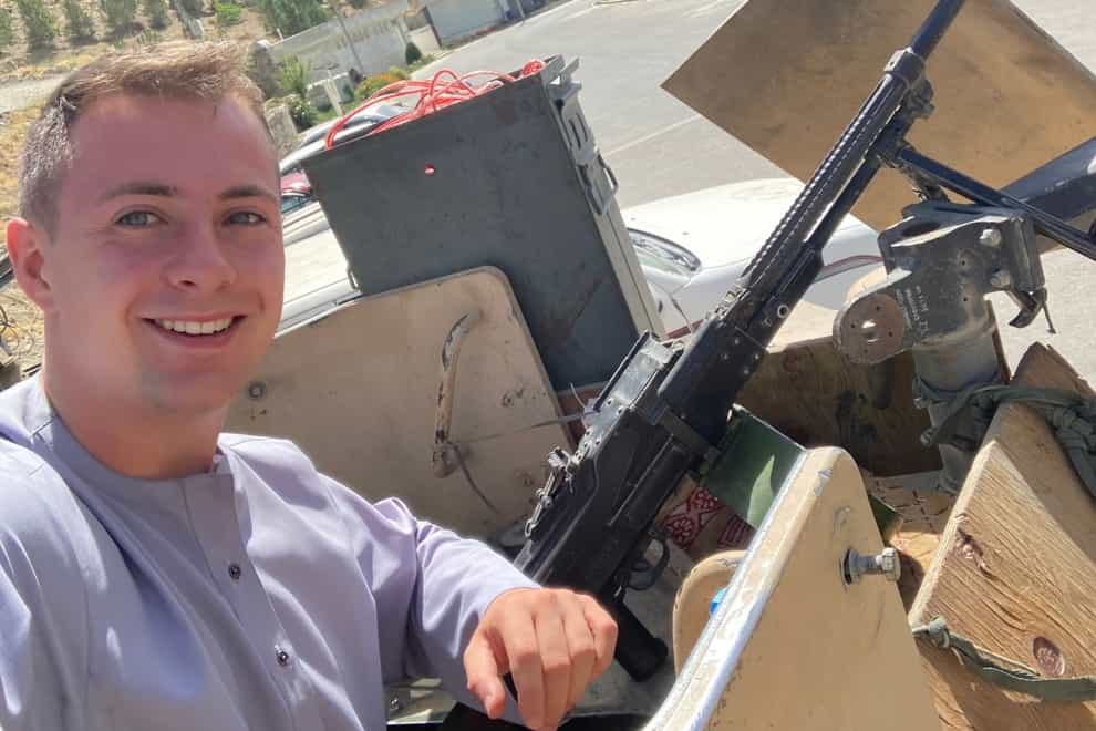 Miles Routledge poses with what is believed to be an Afghan military gun after meeting the soon-to-be defeated army during his visit (Miles Routledge/PA)