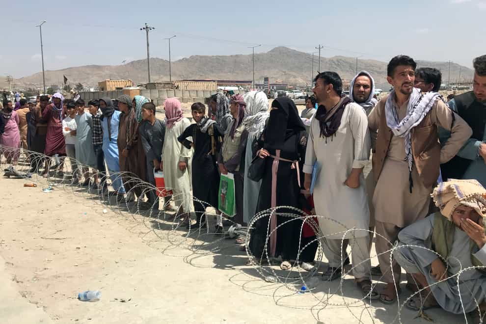 Hundreds of people gather outside the international airport in Kabul, Afghanistan (AP)