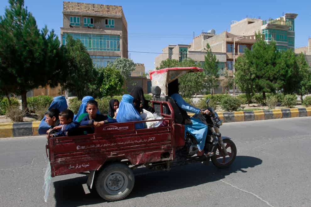 Afghan women and children travel in a motorcycle cart during fighting between Taliban and Afghan security forces in Herat province, west of Kabul (Hamad Sarfarazi/AP)