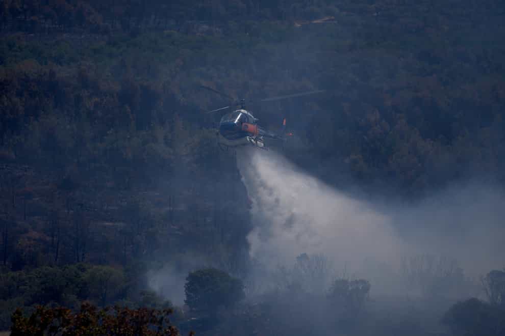 An helicopter drops water on a wildfire near Le Luc, southern France (Daniel Cole/PA)