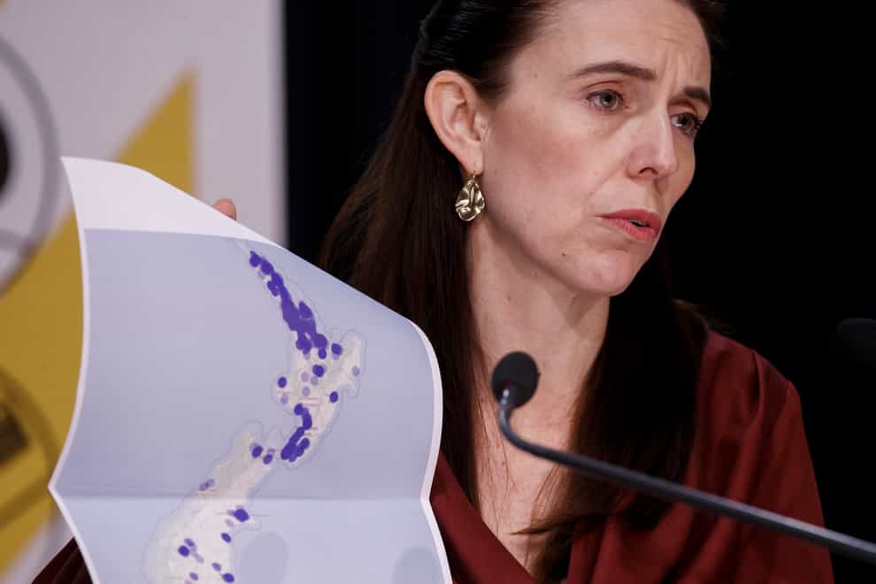 New Zealand prime minister Jacinda Ardern holds a map of New Zealand during a Covid-19 update press conference in Wellington, New Zealand (Robert Kitchin/AP)