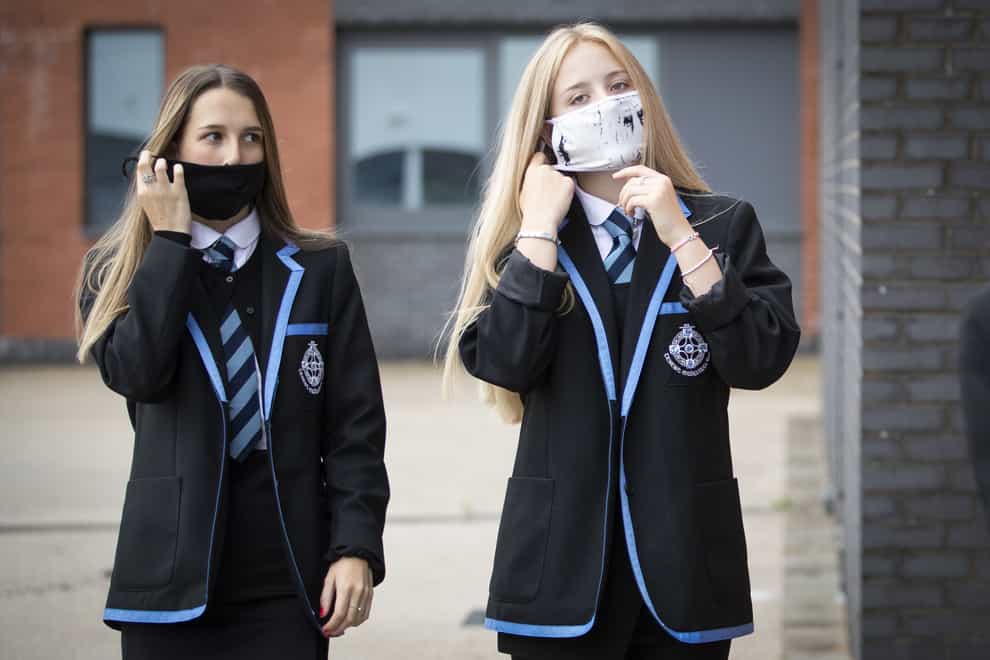 Leah McCallum and Rebecca Ross, S4 students at St Columba’s High School, Gourock, put on their protective face masks as the requirement for secondary school pupils to wear face coverings when moving around school comes into effect from today across Scotland (PA)
