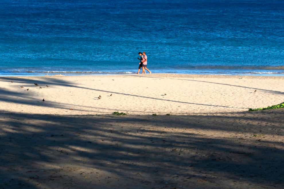 A couple walks on a beach near Waimea, Hawaii (Caleb Jones/AP)