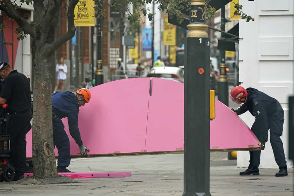 Workers remove part of a large pink strcture that had been used by environmental activists from Extinction Rebellion to block the junction of Long Acre and Upper St Martin’s Lane in London.