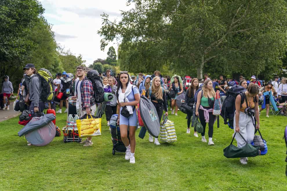 Festivalgoers walk along the towpath of the River Thames as they arrive for the Reading Festival (Steve Parsons/PA)