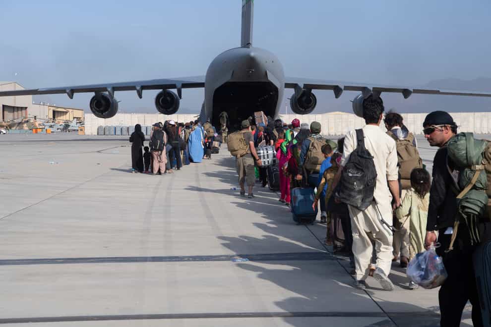US Air Force loadmasters and pilots assigned to the 816th Expeditionary Airlift Squadron, load people being evacuated from Afghanistan onto a U.S. Air Force C-17 Globemaster III at Hamid Karzai International Airport in Kabul, Afghanistan (Master Sgt Donald R Allen/US Air Force via AP)