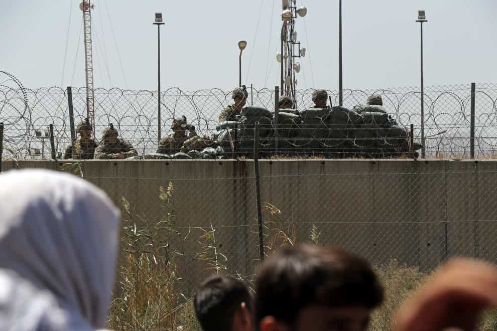 US soldiers stand guard inside the airport walls (Wali Sabawoon/AP)