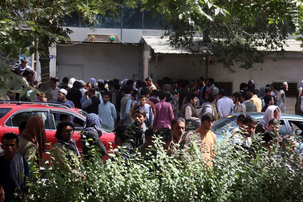 Afghans wait for hours to try to withdraw money, in front of Kabul Bank (AP)