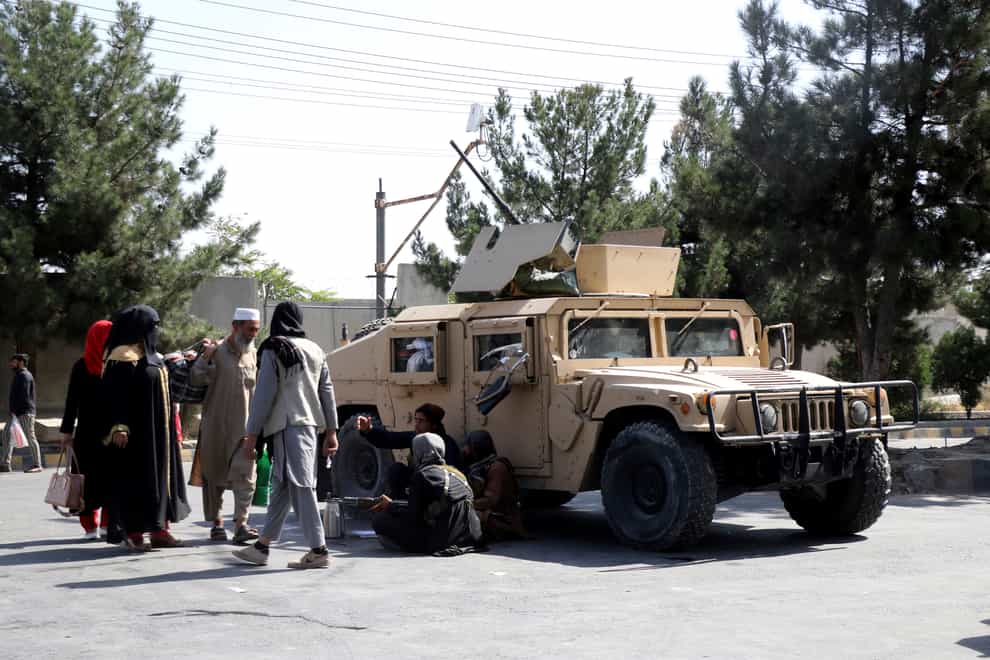 Taliban fighters on guard outside the airport in Kabul (Wali Sabawoon/AP)
