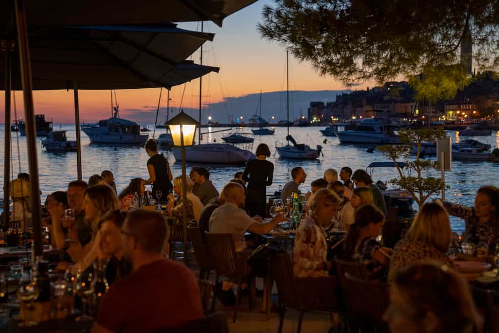 Holidaymakers sit in a seafront restaurant, in the Adriatic town of Rovinj, Croatia (Darko Bandic/AP)