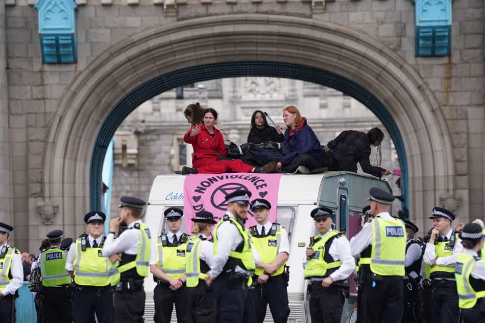 Police by a caravan on Tower Bridge, central London after members of Extinction Rebellion blocked the road (Stefan Rousseau/PA)