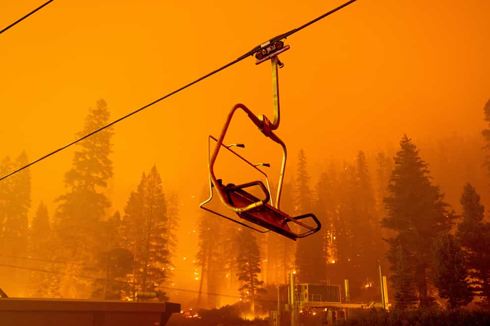 The Caldor Fire burns as a chairlift sits motionless at the Sierra-at-Tahoe ski resort (Noah Berger/AP)
