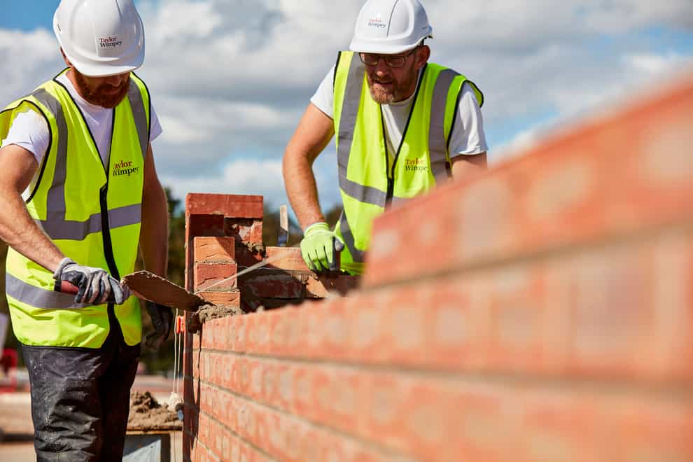 Workers laying bricks at a construction site (Taylor Wimpey/PA)