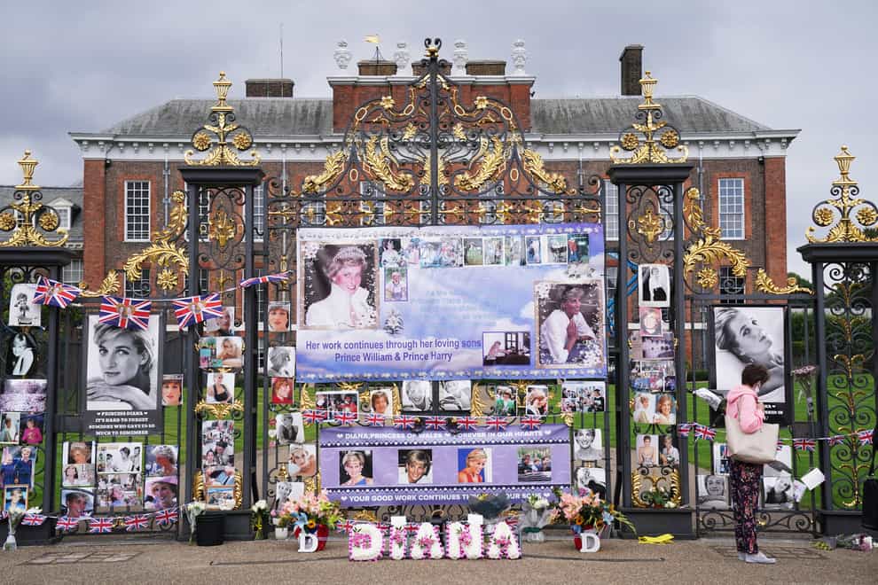 People look at tributes left at the gates of Kensington Palace in London on the 24th anniversary of the death of Diana, Princess of Wales. Picture date: Tuesday August 31, 2021.