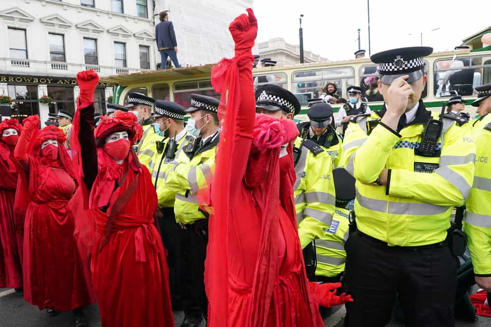 Police and demonstrators with a bus parked on London Bridge in central London during a protest by members of Extinction Rebellion (Ian West/PA)