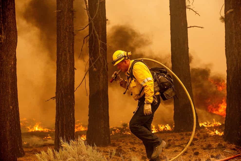 A firefighter battles a blaze near South Lake Tahoe, California (Noah Berger/AP)