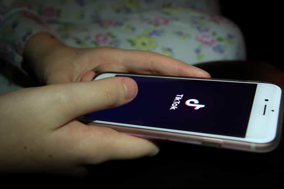 A young girl uses the TikTok app on a smartphone (Peter Byrne/PA)