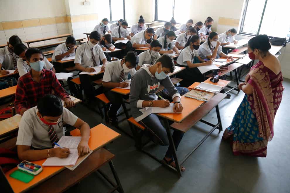 Students wearing face masks as a precaution against coronavirus, attend classes in Ahmedabad, India (Ajit Solanki/AP)
