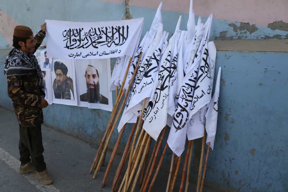 Taliban fighter looks at Taliban flags in Kabul, Afghanistan (AP)