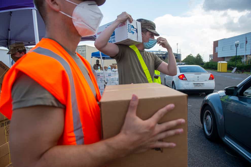 Louisiana National Guard troops place water and MREs into the back of cars at the Shrine on Airline on Wednesday, Sept. 1, 2021, in Metairie, La., as the region tries to rebuild following Hurricane Ida. (Chris Granger/The Times-Picayune/The New Orleans Advocate via AP)