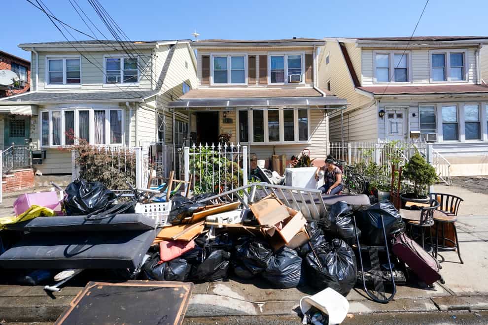 A woman sits next to her drenched belongings (Mary Altaffer/AP)