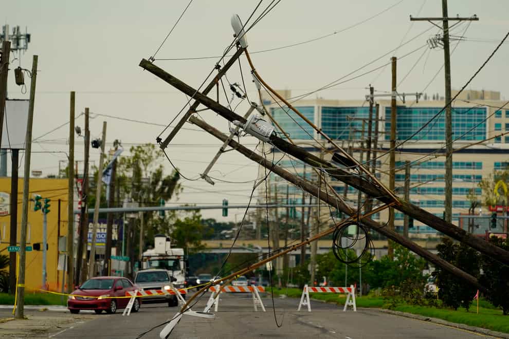 Vehicles are diverted around utility poles damaged by the effects of Hurricane Ida in New Orleans (Eric Gay/AP)