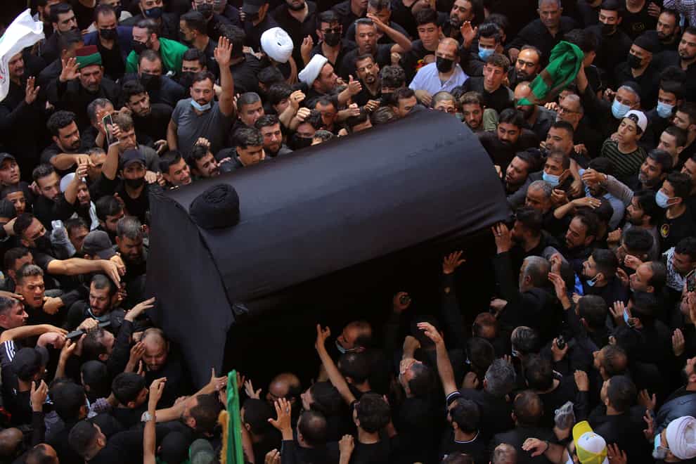 Mourners carry the coffin of Grand Ayatollah Sayyid Mohammed Saeed al-Hakim inside the holy shrine of Imam Hussein (AP)