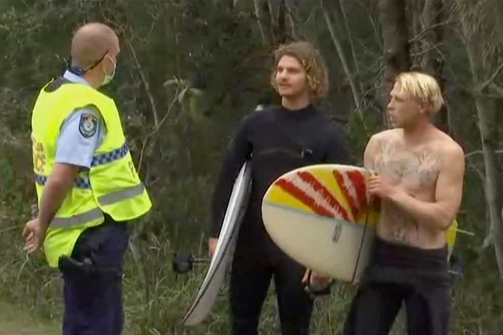 A policeman talks to surfers near the beach in Coffs Harbour, Australia, where a man was fatally bitten by a shark (Australian Broadcasting Corporation/AP)