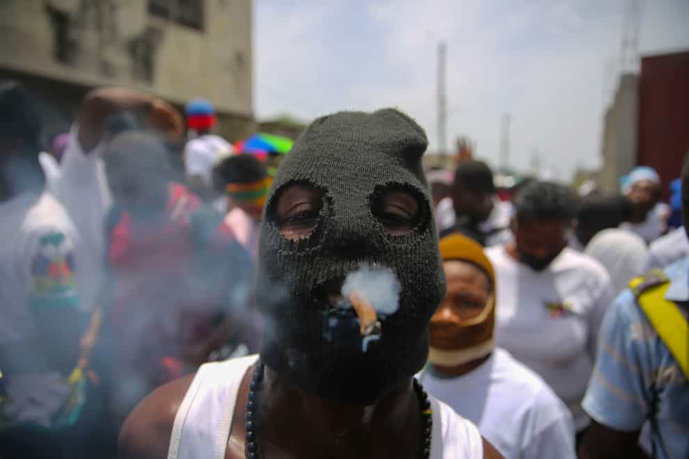 A member of the gang led by Jimmy Cherizier, alias Barbecue, a former police officer who heads a gang coalition known as G9 Family And Allies, joins a march to demand justice for murdered Haitian President Jovenel Moise (Joseph Odelyn/AP)