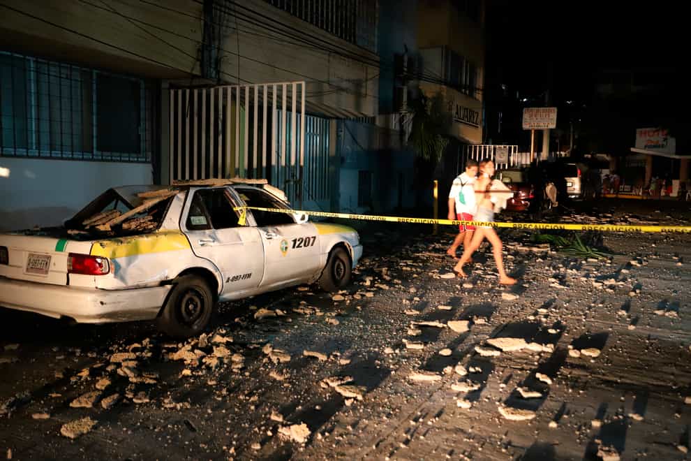 A taxi damaged by falling debris in Acapulco (Bernardino Hernandez/AP)