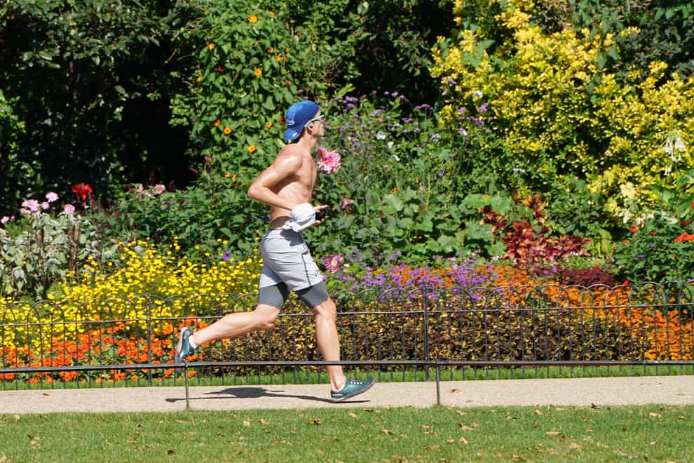 A man exercises in St James’s Park in central London during a spell of hot weather (Stefan Rousseau/PA)